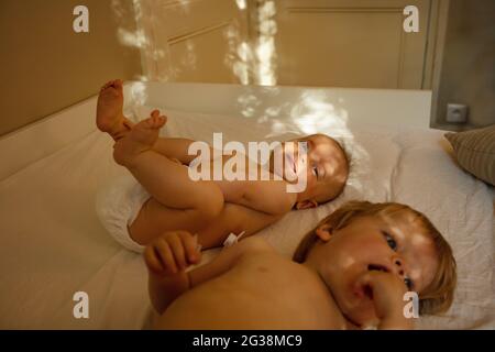 Deux petits bébés heureux se sont posé sur le lit à la maison Banque D'Images