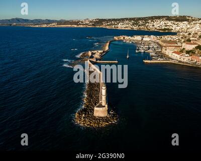 Vue aérienne par drone du phare vénitien emblématique à l'entrée du vieux port pittoresque de Chania au coucher du soleil sur l'île de Crète, Grèce. Banque D'Images