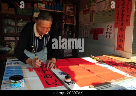 Yang Shilu, ancien lieutenant de police de plancher de 82 ans, qui avait rejoint la Seconde Guerre mondiale Avant de se lancer dans la guerre contre le communisme chinois, il était encore en bonne santé et capable de voyager un long voyage même s'il avait une blessure d'un fragment de bombe et d'une cicatrice chirurgicale, diagonalement dans le corps de l'épaule à la hanche. Son seul revenu de l'écriture de poèmes de bon augure n'est pas suffisant pour un voyage à la maison et la recherche de parents qui n'ont pas été en contact depuis plus de 60 ans dans la ville de Baoshan. Il croit toujours qu'il trouvera sa maison une fois qu'il y sera, bien que les environs aient beaucoup changé. Chiang Mai Banque D'Images