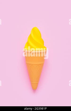 Glace jaune sur fond rose. Minimalisme, concept d'été, vue de dessus, espace de copie, vertical Banque D'Images