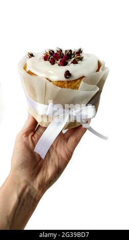 Tenue à la main, tons panettone décoré de roses, de papier et d'un noeud Banque D'Images