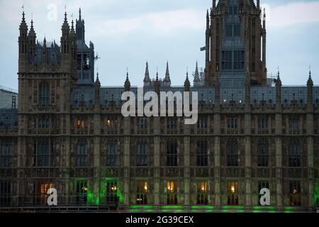 Le Palais de Westminster, à Londres, est illuminé de vert en souvenir des 72 morts perdues et de tous ceux touchés par la tragédie de l'incendie de la tour Grenfell en 2017. Date de la photo: Lundi 14 juin 2021. Banque D'Images