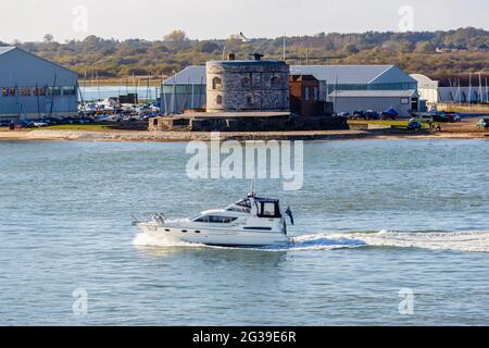 Un bateau à moteur navigue en police de caractères du château de Calshot, un fort d'artillerie construit par Henry VIII sur le détroit de Calshot pour défendre le passage maritime vers Southampton Banque D'Images