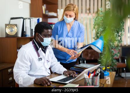 Médecin et femme en masque de protection infirmière ayant une journée productive Banque D'Images