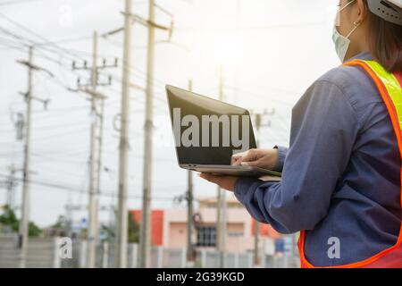 Femme ingénieur tenant un ordinateur portable travaillant à l'extérieur. La femme employée utilise la technologie informatique Banque D'Images