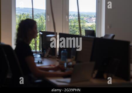 Gelnhausen, Allemagne. 14 juin 2021. Une femme est assise dans l'espace de travail de la vallée de Kinzig devant une fenêtre derrière laquelle la nature peut être vue. (À dpa "nature et travail: Un collègue dans la campagne comme une alternative au bureau") Credit: Sebastian Gollnow/dpa/Alay Live News Banque D'Images