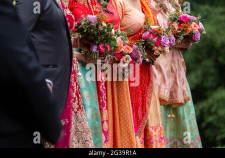 Mariée et demoiselle d'honneur portant des saris et tenant des fleurs lors d'un mariage en Australie Banque D'Images