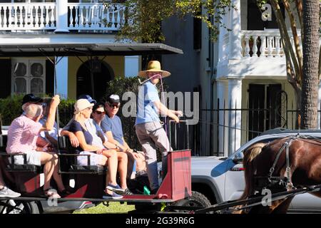 Les touristes voyagent en buggy à cheval tandis que le chauffeur explique le quartier historique des époques coloniales et de la guerre civile dans la ville historique de Charleston, Caroline du Sud. Banque D'Images