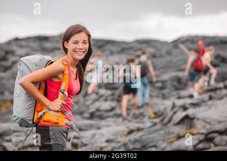 Hawaï Volcano randonnée aventure Happy Asian femme avec sac à dos à Big Island, Hawaï. Groupe de touristes qui marchent sur le sentier de la lave noire Banque D'Images