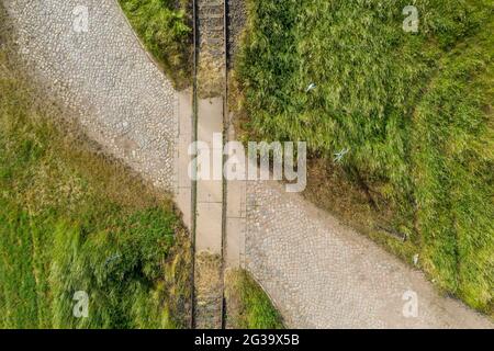 Wanzleben, Allemagne. 13 juin 2021. Une voie ferrée traverse un vieux chemin pavé sur une ligne désuée. (Prise de vue avec un drone). Credit: Stephan Schulz/dpa-Zentralbild/ZB/dpa/Alay Live News Banque D'Images