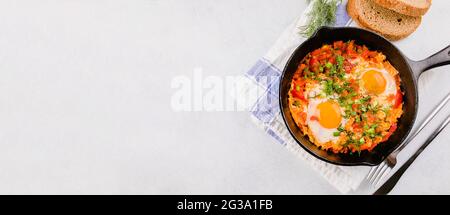 Repas de keto, régime. Shakshuka. Œufs pochés avec sauce tomate. Concept de la nourriture pour le petit déjeuner, vue du dessus Banque D'Images