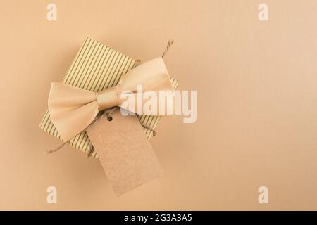 Boîte cadeau avec étiquette pour texte sur fond neutre. Concept de la fête des Pères heureux. Image monochrome Banque D'Images