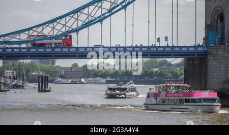 Bateau de croisière sur le fleuve de Londres avec des passagers portant un masque facial navigue sous Tower Bridge avec bus rouge en voiture lors d'une journée chaude. 12 juin 2021 Banque D'Images