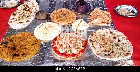 Variété de chapati cuits, prantha, pizza et autres plats exposés au restaurant indien Banque D'Images