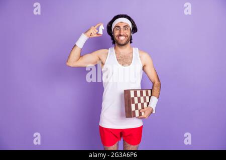 Photo de jeune heureux gai funky drôle homme dans les verres tenir chessboard et figure d'échecs isolé sur fond violet de couleur Banque D'Images