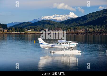 Scène tranquille, hydravion à l'ancre sur un lac clair et calme avec un magnifique fond de montagne enneigé Banque D'Images