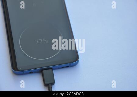 Vue en hauteur d'un smartphone connecté à l'aide d'un câble de chargement USB de type C avec espace négatif, chargement du téléphone portable - photo de stock Banque D'Images