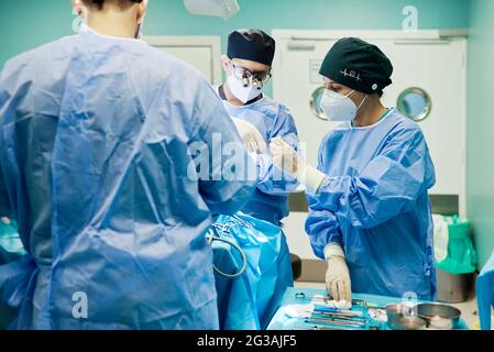 Chirurgien méconnaissable avec assistants pendant l'opération en clinique Banque D'Images