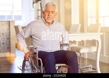 Homme âgé satisfait en fauteuil roulant après un accident vasculaire cérébral dans une maison de soins infirmiers Banque D'Images