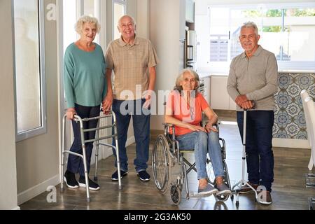 Groupe de personnes âgées ayant des fauteuils roulants et des aides à la marche dans des maisons de retraite ou des maisons de soins infirmiers Banque D'Images