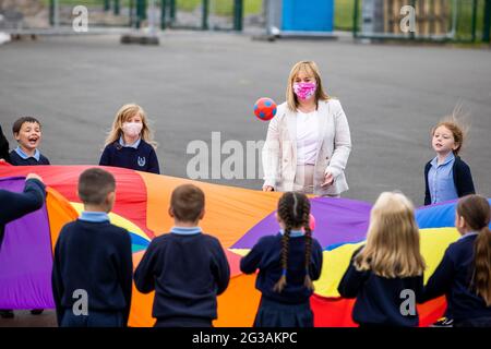 Michelle McIlveen (costume blanc) jouant avec des enfants de P4 lors de son premier engagement en tant que ministre de l'éducation d'Irlande du Nord en visite à l'école primaire et pépinière de Ballysillan dans le nord de Belfast. Banque D'Images