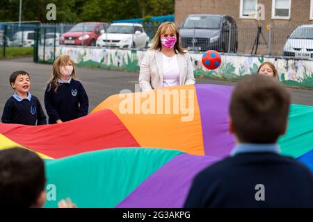 Michelle McIlveen (costume blanc) jouant avec des enfants de P4 lors de son premier engagement en tant que ministre de l'éducation d'Irlande du Nord en visite à l'école primaire et pépinière de Ballysillan dans le nord de Belfast. Banque D'Images