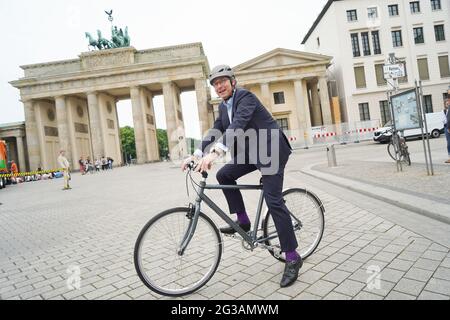 15 juin 2021, Berlin: Andreas Scheuer (CSU), ministre fédéral des Transports, monte à vélo devant la porte de Brandebourg après la remise de deux nouveaux véhicules de collecte de déchets de piles à combustible pour le Berliner Stadtreinigungsbetriebe (BSR). Photo: Jörg Carstensen/dpa Banque D'Images