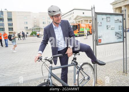 15 juin 2021, Berlin: Andreas Scheuer (CSU), ministre fédéral des Transports, monte à vélo devant la porte de Brandebourg après la remise de deux nouveaux véhicules de collecte de déchets de piles à combustible pour le Berliner Stadtreinigungsbetriebe (BSR). Photo: Jörg Carstensen/dpa Banque D'Images