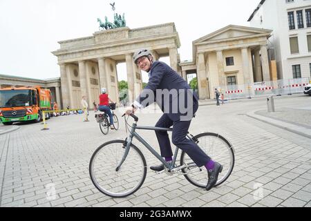 15 juin 2021, Berlin: Andreas Scheuer (CSU), ministre fédéral des Transports, monte à vélo devant la porte de Brandebourg après la remise de deux nouveaux véhicules de collecte de déchets de piles à combustible pour le Berliner Stadtreinigungsbetriebe (BSR). Photo: Jörg Carstensen/dpa Banque D'Images