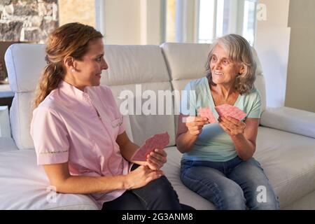 Mère et fille jouant des cartes comme formation de mémoire dans la maison de soins infirmiers ou à la maison Banque D'Images