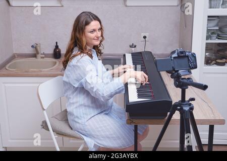 Gros plan d'une femme enceinte dans une cravate bleue à un instrument de musique, un piano dans la cuisine Banque D'Images