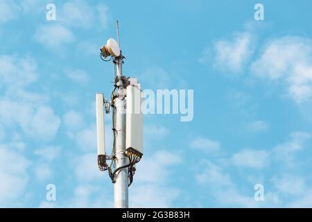 Tour de cellules et autres antennes de télécommunication sur la flèche contre le fond des nuages et du ciel Banque D'Images