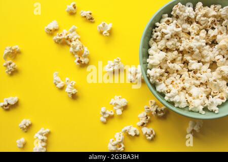 Délicieux pop-corn dans un bol et sur fond jaune gros plan. Concept de restauration et d'en-cas. Banque D'Images