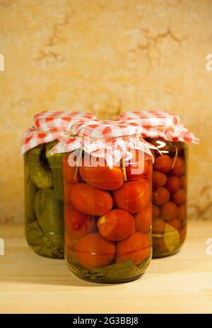 Légumes de Canneds faits maison. Tomates fraîches en conserve dans un pot en verre sur fond flou. Banque D'Images