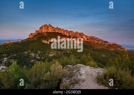 Montserrat face ouest avec quelques formations rocheuses comme Roca Foradada et Serrat de la Portella, au coucher du soleil, vu de Castellferran (Barcelone, Catalogne) Banque D'Images