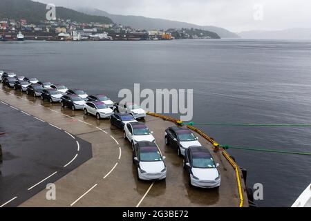 Des voitures sont en file sur le quai du port qui attend d'être chargées à Bergen, en Norvège Banque D'Images