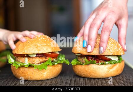 Main de petit enfant et main de mère sur des hamburgers faits maison. Le concept de la cuisine délicieuse à la maison avec votre enfant Banque D'Images