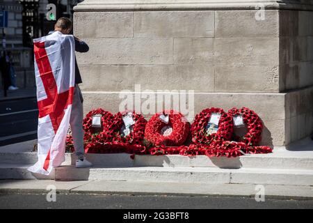 Un fan de football patriotique d'Angleterre, drapé dans le drapeau de la Croix de Saint George, se tenait au mémorial de guerre de Cenotaph à Whitehall Londres, en Angleterre, Banque D'Images