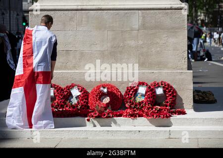 Un fan de football patriotique d'Angleterre, drapé dans le drapeau de la Croix de Saint George, se tenait au mémorial de guerre de Cenotaph à Whitehall Londres, en Angleterre, Banque D'Images