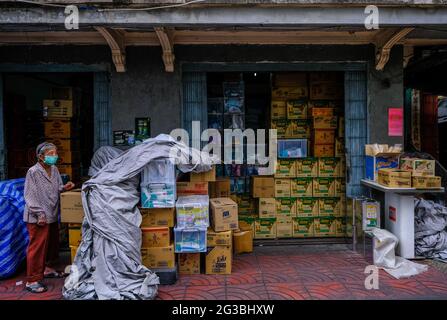 Une femme de shopping âgée se tient à l'extérieur de ses locaux à Chinatown, Bangkok, Thaïlande Banque D'Images