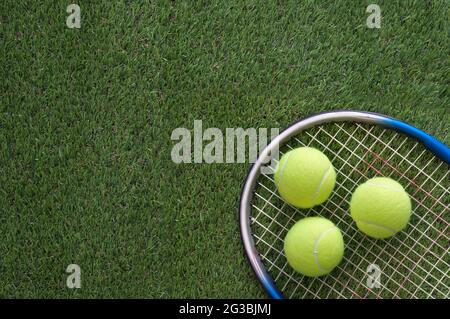 Raquette de tennis avec balles sur le terrain d'herbe Banque D'Images