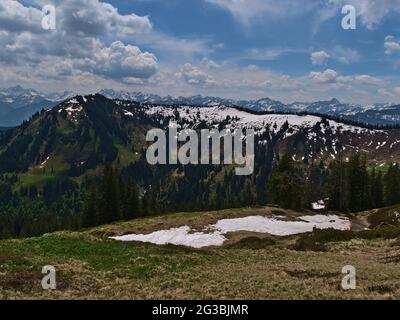 Paysage de montagne dans les Alpes d'Allgäu dans le sud de la Bavière, en Allemagne par beau temps au début de l'été avec neige résiduelle, prairies, arbres et montagnes. Banque D'Images