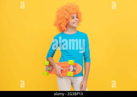 bonne fille de l'adolescence dans la perruque fantaisie clown tenir le panneau de penny, l'enfance Banque D'Images