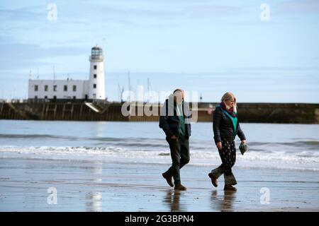 Un couple marchant sur la plage de Scarborough dans le nord du Yorkshire alors que l'épidémie de coronavirus s'aggrave au Royaume-Uni et que les gens observent 'social distanci Banque D'Images