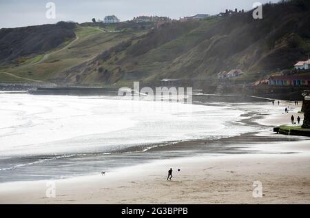 Un jeune garçon joue au football sur la plage de Scarborough, dans le nord du Yorkshire, alors que l'épidémie de coronavirus s'aggrave au Royaume-Uni et que les gens observent la « socia » Banque D'Images