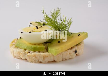 Pain de riz croustillant, avocat, tranches d'œufs durs et aneth frais Banque D'Images