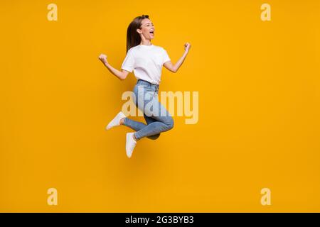 Pleine longueur de la photo de taille de corps de gaie surjoyeuse fille saut de ventilateur gestant comme le gagnant hurlant isolé couleur jaune vif arrière-plan Banque D'Images