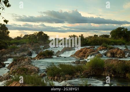 Paysage fluvial au coucher du soleil des célèbres chutes d'eau Li Phi ou Tat Somphamit, sur le Mékong, vu de l'île Don Khon au Laos Banque D'Images