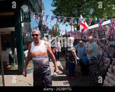 Les gens font du shopping à Epping Market, Epping, Essex, Angleterre, avec les drapeaux Union Jack et Saint George’s Cross affichés. Ambiance traditionnelle de marché de rue britannique. Banque D'Images