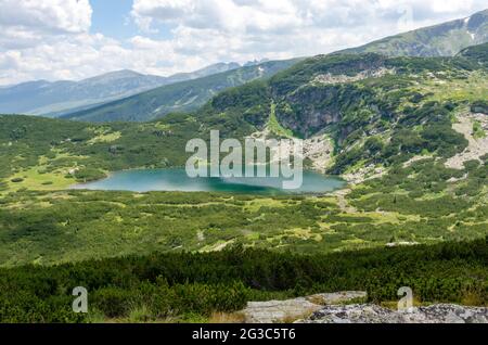 Panorama sur la montagne de Rila en un voyage pour sept lacs de Rila. Bulgarie. Le lac inférieur est le plus bas des sept lacs Rila. Banque D'Images